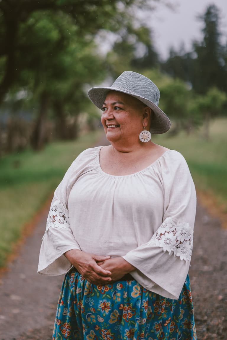 A woman in a wide brimmed hat and embroidered blouse, close