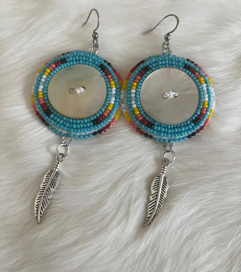 Turquoise beaded earrings with a shell button centre and silver feather charms