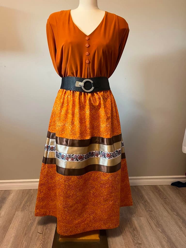 Orange batik ribbon skirt with brown and cream ribbons and a printed floral band